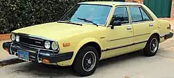 Front three-quarter view of a four-door car with a three-box body style.