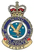 Military crest for 78 Wing, Royal Australian Air Force, with eagle carrying sword in front of Southern Cross constellation; the motto reads "Fight"