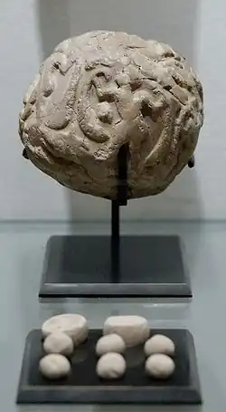 Globular envelope with a cluster of accounting tokens. Clay, Uruk period. From the Tell of the Acropolis in Susa. Susa II or "Uruk period"
