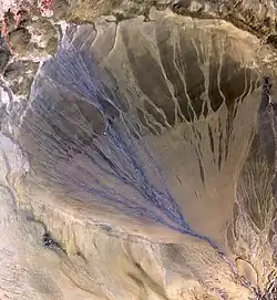 A 60&nbsp;km long Megafan across the desolate landscape between the Kunlun and Altun mountain ranges that form the southern border of the Taklamakan Desert in Xinjiang. The left side is the active part of the fan, and appears blue from water flowing in the many small streams
