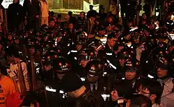 A tightly bundled group of police officers in riot gear assembled in Jackson Road