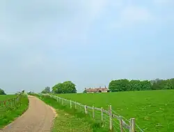 country land, green fields with old house in the background