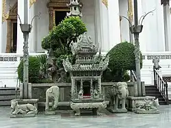A stone Chinese temple style incense burner between two stone elephants, located at Wat Suthat