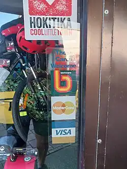 Bankcard logo shown on a shop window sticker as an accepted credit card in Hokitika in 2025.