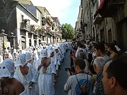 A Christian procession with penitents mortifying the flesh with spugnas in the Italian city of Guardia Sanframondi