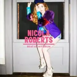 A red haired woman wearing a colored dress sitting on a window. In front of her, it is written "NICOLA ROBERTS BEAT OF MY DRUM" in pink.