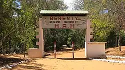 A dirt road runs under a decorated, arching sign demarcating the Berenty Private Reserve.