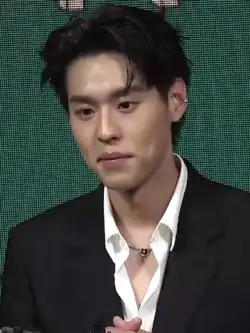 Billkin in tuxedo, in front of LED display