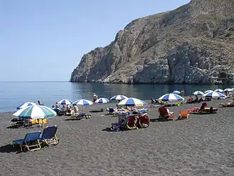 Kamari beach. The old customs house arch can be seen near the right edge of the image, right above the sea-level.