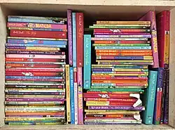 Bookshelf with stacks of books by Roald Dahl