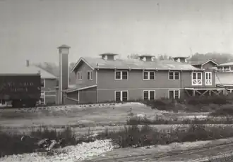 Long, two-story building next to a railroad