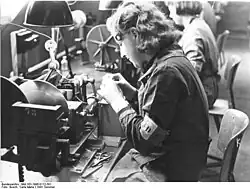 Danish detainee wears a D armband during assignment to forced labor in factory outside the camp.