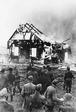 Image 8German soldiers and locals watch a Lithuanian synagogue burn in 1941. (from History of Lithuania)