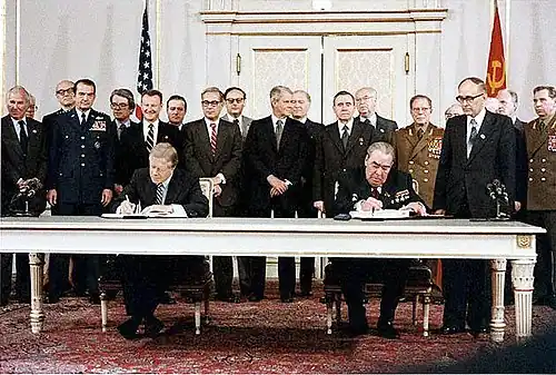Carter and Brezhnev sitting next to each other.