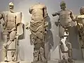 The central figures of the east Pediment of the Temple of Zeus at Olympia. The main figure is Zeus, to his left is Pelops and to his right is Oinomaus in a chariot race.