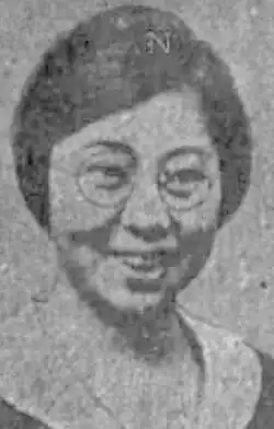 A smiling Japanese woman wearing glasses, from a 1928 newspaper photo