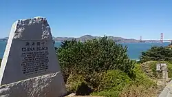 China Beach trailhead marker with bay and Golden Gate Bridge in background
