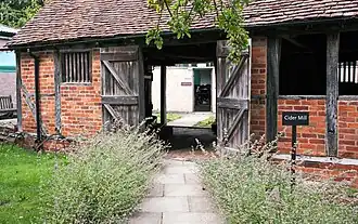 Lavender outside of a red brick cider mill building with the doors open.