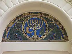 Tile art above left-hand doorway (west side).