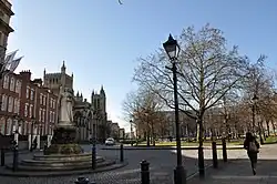 View of College Green showing Queen Victoria statue, Cathedral and Council House, with restored cast iron lamp post in foreground