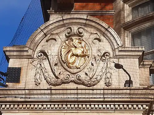 Terracotta corner decoration with golden griffin emblem