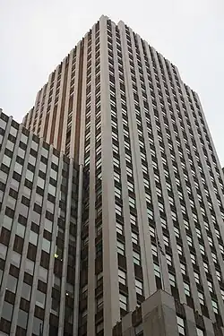 The original tower and annex as seen from 42nd Street. The facade of the tower is composed of vertical window bays that are separated by white-brick wall piers, as well as multicolored brick patterns. The spandrel panels between the windows on each story are made of reddish-brown and black brick, laid in a contrasting pattern.