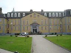 Large yellow three-storey building with tall narrow windows