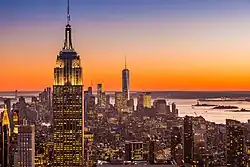 The Empire State Building at sunset looking south. Buildings can be seen in the distance, including One World Trade Center.