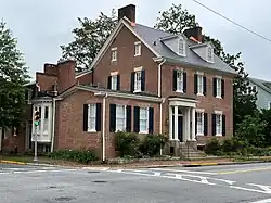 two and a half-story brick building with wing