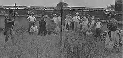 Film makers stand in front of actors while filming the movie.