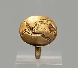 A ring with a female figure and a griffin. Archanes, Phourni, 1700–1450 BC.