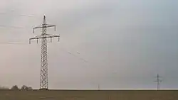 Suspension towers with garland-like communication cable on the ground conductor