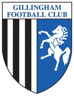 A shield with the words "Gillingham Football Club" in the top portion and the remainder divided into two sections, the left containing black and white vertical stripes and the right a depiction of a white horse rearing up on its hind legs on a blue background