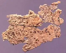 Fragment of ancient Chinese paper map with features in black ink, found on the chest of the occupant of Tomb 5 of Fangmatan, Gansu in China in 1986, from early Western Han, 2nd century BC, 5.6 cm × 2.6 cm (2.2 in × 1.0 in).