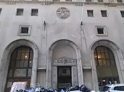 The entrance on Beaver Street, with three stone archways of identical height. The center arch is a service entrance.