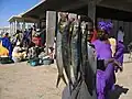 Boy displaying a couple of fish at the Nouakchott fish market