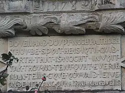 Inscription plaque below coats of arms set into one of the towers
