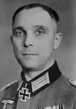 A black-and-white photograph of a man wearing a dark military uniform with a neck order in shape of an Iron Cross.