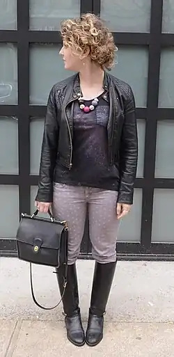 Image 145Woman in 2013 wearing galaxy-print top, leather moto jacket, statement necklace, and riding boots. (from 2010s in fashion)