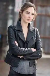An image of a woman with brown hair and dark clothes looking towards the camera.
