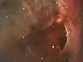 Hubble detail of a region west of the Trapezium, showing arcs and bubbles formed when stellar winds collide with existing interstellar material