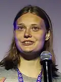 A woman with medium-length hair wearing a black shirt and smiling.