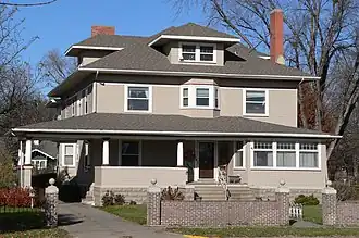 Two-story house with extensive porch, dormers, brick chimneys