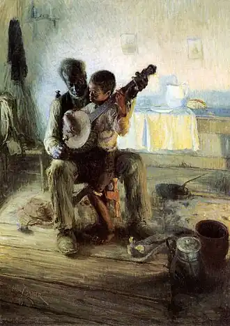 A boy holding a banjo seated on an old man's lap