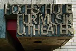 Old name fragment shown above the entrance of the main building constructed in 1970–73