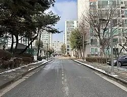 Inside the enclave. The buildings to the left and right are part of the enclave. The building at the end of the road is an unrelated commercial building (2024)