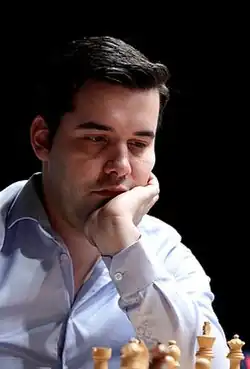 Nepomniachtchi looking over a chess board.