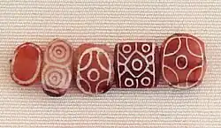 Indian carnelian beads, white design etched with acid, imported to Susa in 2600–1700 BC. Found in the tell of the Susa acropolis. Louvre Museum, reference Sb 17751.[15][16][17] These beads are identical with beads found in the Indus Civilization site of Dholavira.[18]