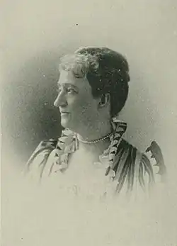 B&W portrait photo of a middle-aged woman with her hair in an up-do