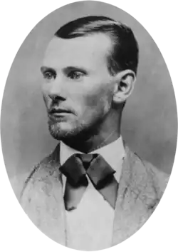 Oval-shaped black-and-white portrait photograph of a man with short slicked-back hair
